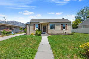 Bungalow featuring a front yard and a mountain view