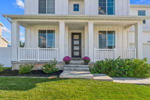 Property entrance featuring a yard and a porch