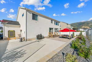 Rear view of property with a mountain view, basketball and a patio area