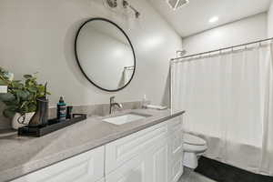 Full bathroom featuring vanity, toilet, shower / tub combo with curtain, and tile patterned floors