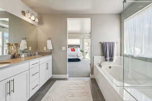 Bathroom featuring vanity, a bath, and tile patterned flooring