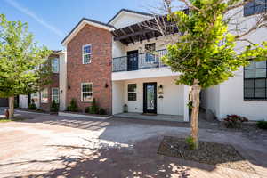 View of front of house with a balcony and a patio area