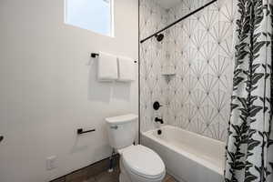 Bathroom with shower / bath combo with shower curtain and toilet