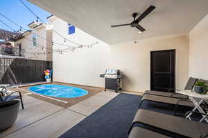 View of swimming pool with area for grilling, ceiling fan, and a patio area