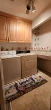 Washroom with separate washer and dryer, a textured ceiling, and cabinets