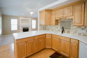 Kitchen featuring a healthy amount of sunlight, kitchen peninsula, sink, and ceiling fan