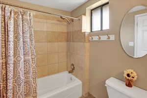 Bathroom featuring toilet and shower / bath combo