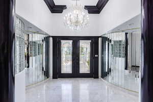 Entrance foyer with a towering ceiling, a chandelier, and french doors