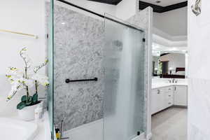 Bathroom with vanity, ornamental molding, and walk in shower