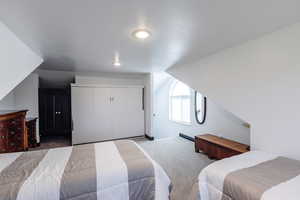 Bedroom featuring a closet, carpet, and vaulted ceiling