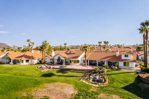 Rear view of property with a lawn and a patio