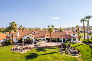 Back of house with a lawn and a patio