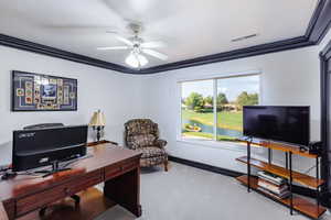 Office space featuring crown molding, ceiling fan, and light carpet