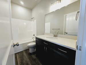 Full bathroom featuring vanity, toilet, hardwood / wood-style floors, and  shower combination