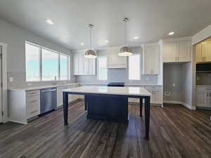 Kitchen featuring white cabinetry, pendant lighting, dark hardwood / wood-style flooring, and stainless steel dishwasher