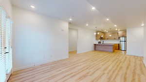 Unfurnished living room featuring light hardwood / wood-style floors and sink