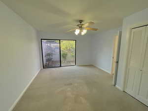 Unfurnished bedroom with ceiling fan and light carpet