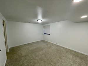 Basement featuring carpet and a textured ceiling