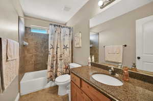 Full bathroom featuring tile patterned flooring, toilet, shower / tub combo, and vanity