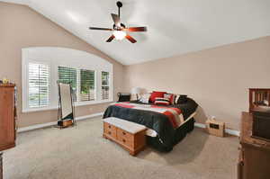 Master bedroom with light carpet, vaulted ceiling, and ceiling fan