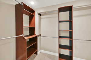 Spacious closet with light carpet