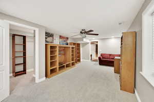 Basement bedroom featuring ceiling fan and light carpet