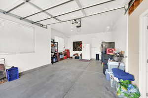 Garage featuring white refrigerator and a garage door opener