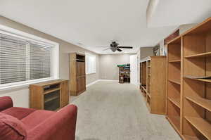 Basement bedroom with ceiling fan and light carpet