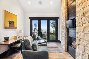 Living room with light wood-type flooring and a stone fireplace