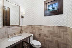 Bathroom featuring toilet, parquet flooring, and vanity