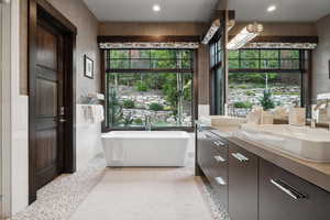 Bathroom featuring vanity, a healthy amount of sunlight, and a bathtub