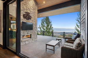 View of patio with an outdoor stone fireplace