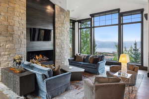 Living room with high vaulted ceiling, hardwood / wood-style flooring, and a fireplace