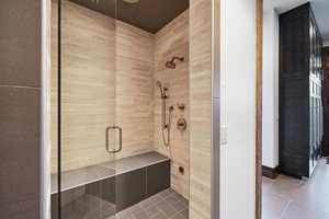 Bathroom with tile patterned flooring and a shower with shower door