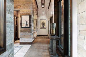 Hall featuring wood walls, wood-type flooring, and beam ceiling