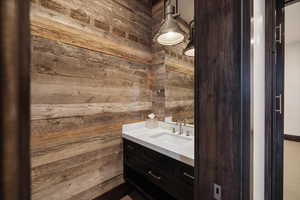 Bathroom featuring vanity and wood walls