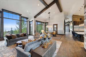 Living room featuring high vaulted ceiling, wood-type flooring, and beam ceiling