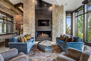 Living room featuring a fireplace, high vaulted ceiling, hardwood / wood-style flooring, and beam ceiling