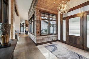 Entrance foyer with lofted ceiling, hardwood / wood-style flooring, and an inviting chandelier