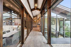 Hall with wood-type flooring and vaulted ceiling with beams