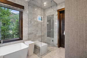 Bathroom featuring tile walls and shower with separate bathtub