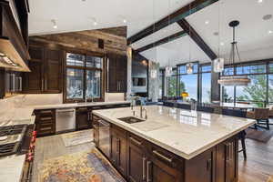 Kitchen with pendant lighting, a breakfast bar, sink, a large island, and light wood-type flooring