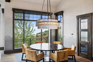 Dining area with wood-type flooring, a wealth of natural light, and an inviting chandelier