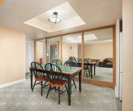 Carpeted dining space with a raised ceiling