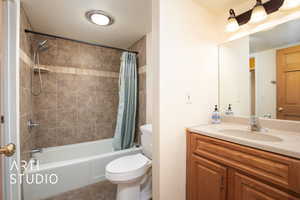 Full bathroom featuring shower / bath combo, tile patterned flooring, toilet, and vanity