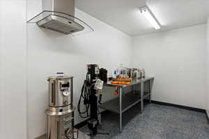 Interior space featuring island exhaust hood and a textured ceiling