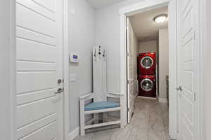 Mudroom featuring stacked washer and dryer