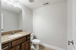 Bathroom with a textured ceiling, vanity, toilet, and tile patterned floors