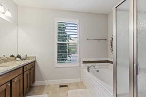 Bathroom with vanity and shower with separate bathtub