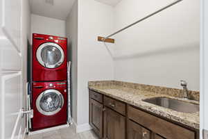 Laundry room featuring stacked washer / drying machine and sink